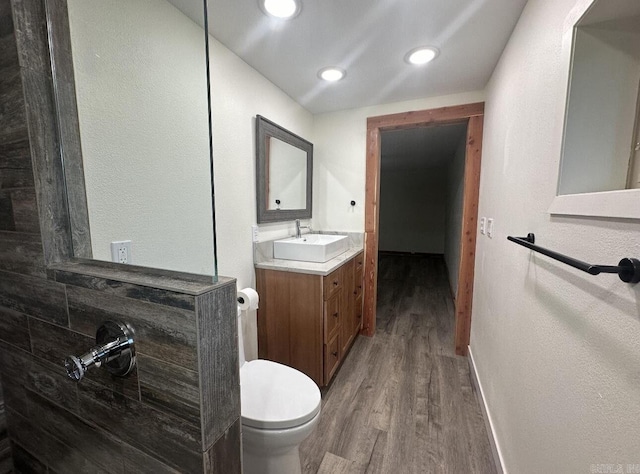 full bath with recessed lighting, toilet, vanity, wood finished floors, and baseboards