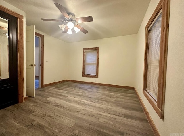 unfurnished bedroom featuring a ceiling fan, baseboards, and wood finished floors