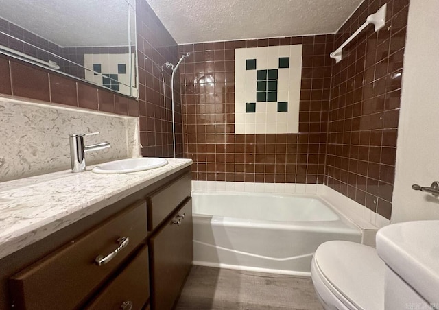 full bath featuring toilet, tub / shower combination, a textured ceiling, vanity, and backsplash