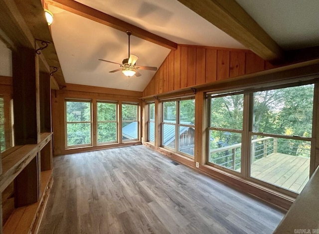 unfurnished sunroom with a ceiling fan, visible vents, and lofted ceiling with beams