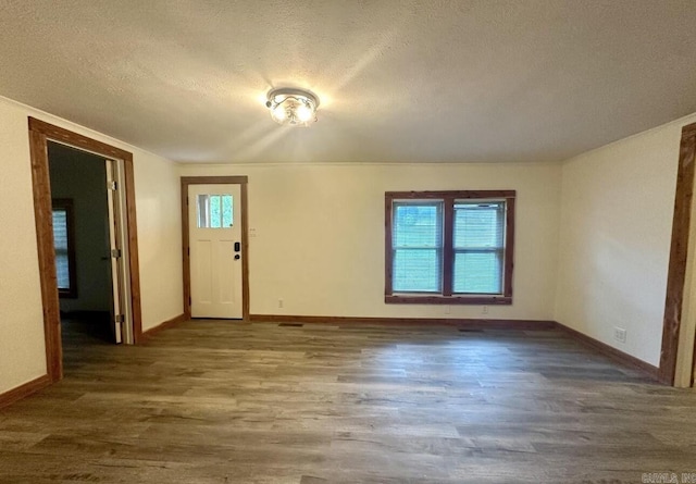 entryway featuring a wealth of natural light, a textured ceiling, baseboards, and wood finished floors