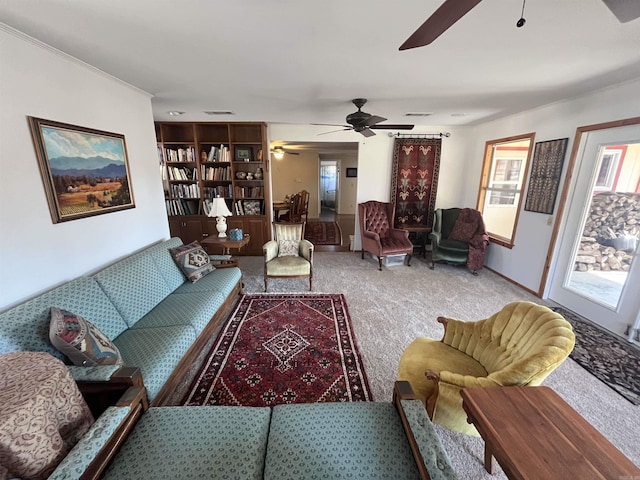 carpeted living area with ceiling fan