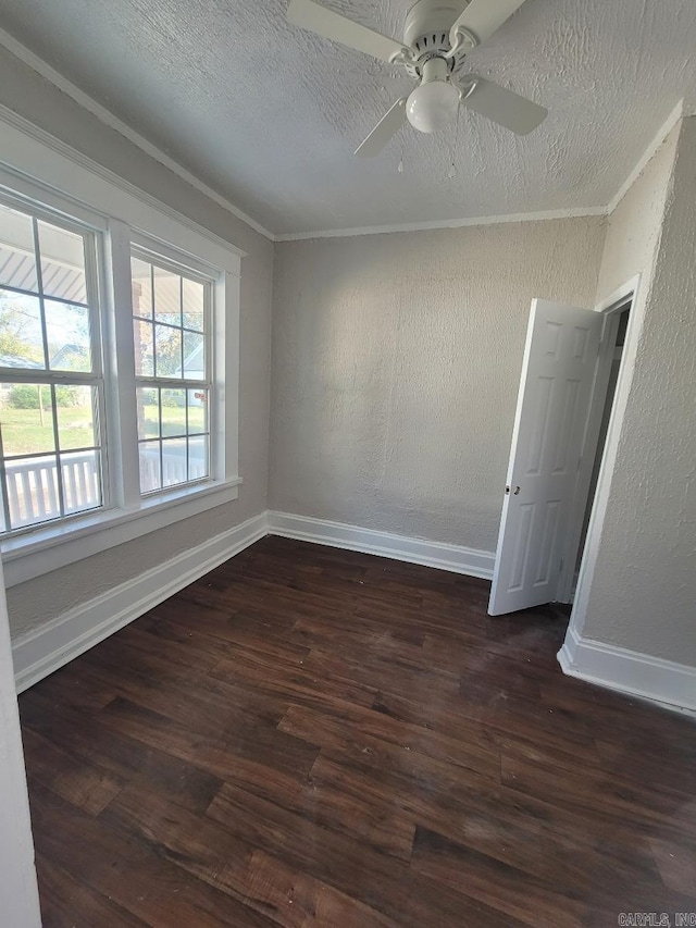 spare room with crown molding, dark wood-style flooring, a textured wall, and a textured ceiling