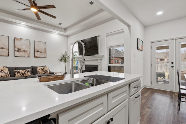 kitchen featuring open floor plan, ornamental molding, a sink, and visible vents