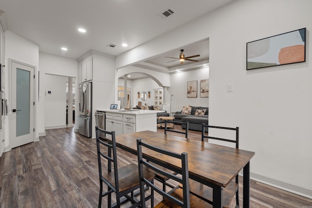 dining room with dark wood-style floors, arched walkways, visible vents, and recessed lighting