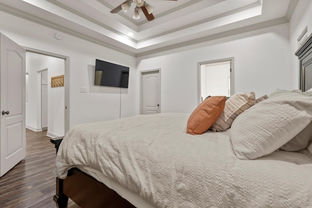 bedroom with crown molding, a raised ceiling, dark wood finished floors, and ceiling fan