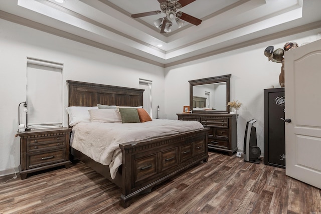 bedroom featuring dark wood-style floors, a raised ceiling, and a ceiling fan