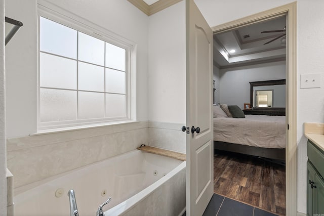 full bath with ensuite bathroom, wood finished floors, a jetted tub, a raised ceiling, and crown molding