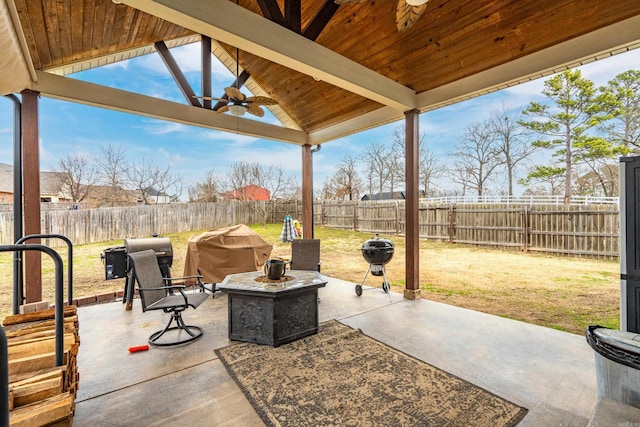 view of patio featuring ceiling fan, a fire pit, grilling area, and a fenced backyard