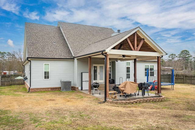 exterior space with a trampoline, french doors, a patio, a ceiling fan, and a fenced backyard