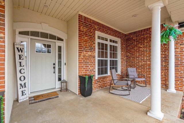 property entrance featuring a porch and brick siding