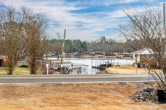 view of yard with a boat dock and a water view