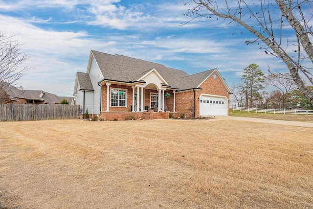 view of front of house with roof with shingles, an attached garage, fence, a front lawn, and brick siding