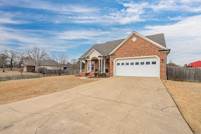 view of front facade featuring driveway, roof with shingles, an attached garage, fence, and brick siding