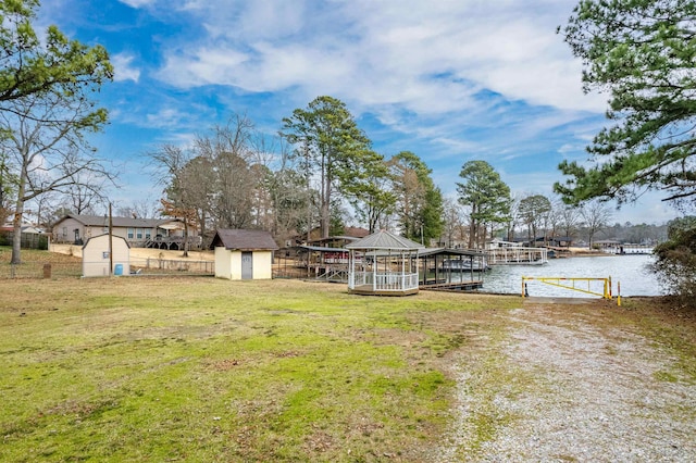 view of yard with a water view, an outdoor structure, and a storage unit