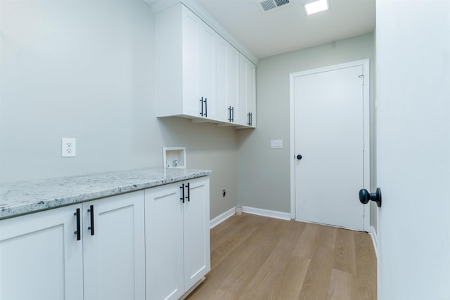 washroom featuring washer hookup, cabinet space, visible vents, light wood-type flooring, and baseboards