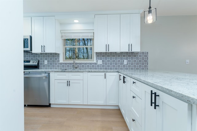 kitchen with stainless steel appliances, light stone counters, backsplash, and a sink