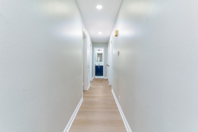 hall featuring recessed lighting, light wood-style flooring, and baseboards