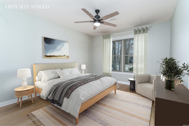 bedroom featuring ceiling fan, wood finished floors, visible vents, and baseboards