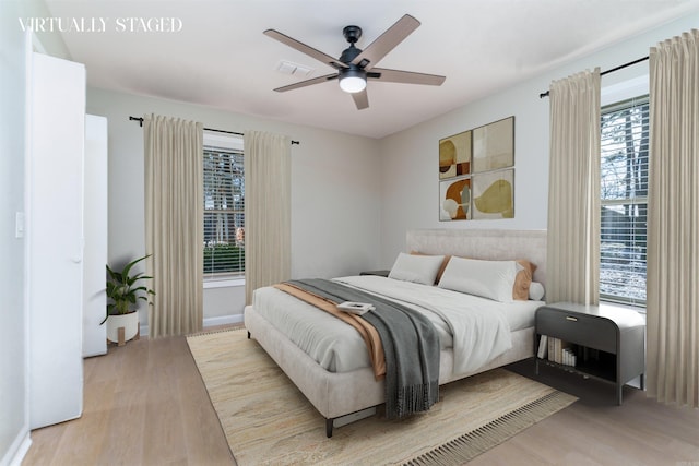 bedroom with light wood-type flooring and a ceiling fan