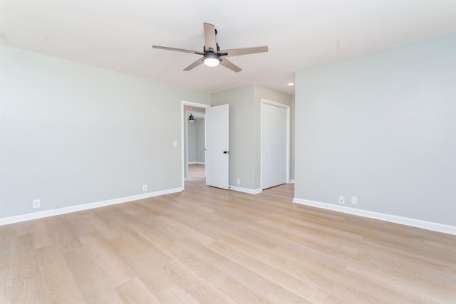 spare room featuring light wood-type flooring, ceiling fan, and baseboards