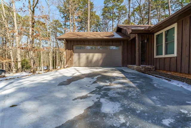 view of side of home with a garage, driveway, and board and batten siding