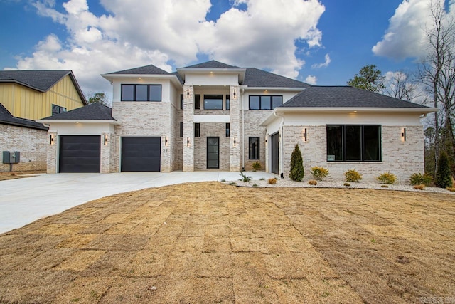 prairie-style home with a garage, driveway, brick siding, and a front lawn