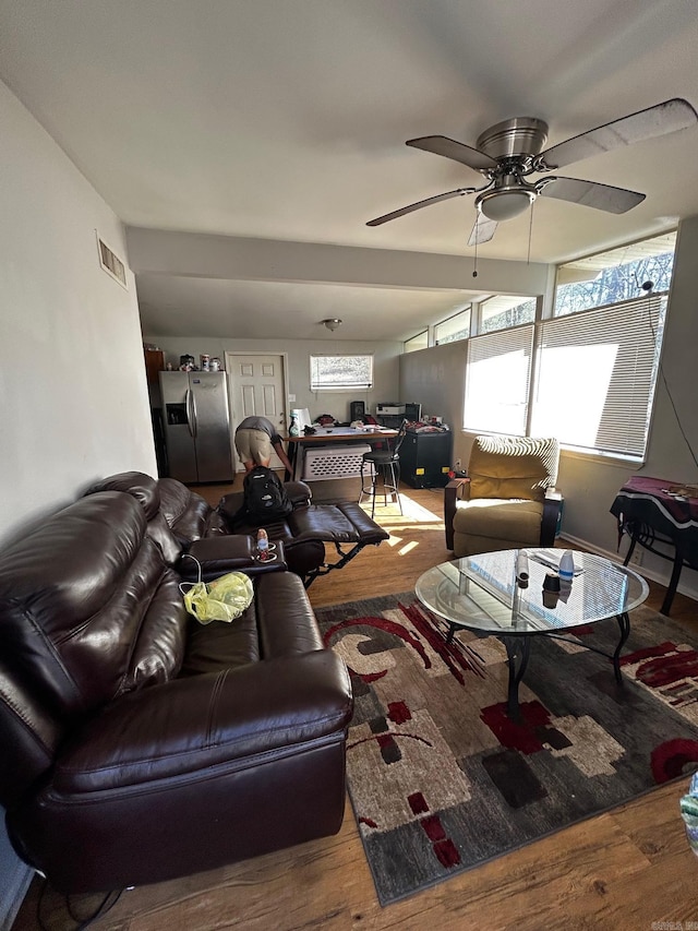 living room featuring ceiling fan, visible vents, and wood finished floors