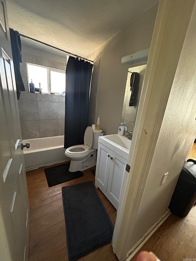 full bathroom with toilet, wood finished floors, vanity, vaulted ceiling, and shower / bath combination with curtain