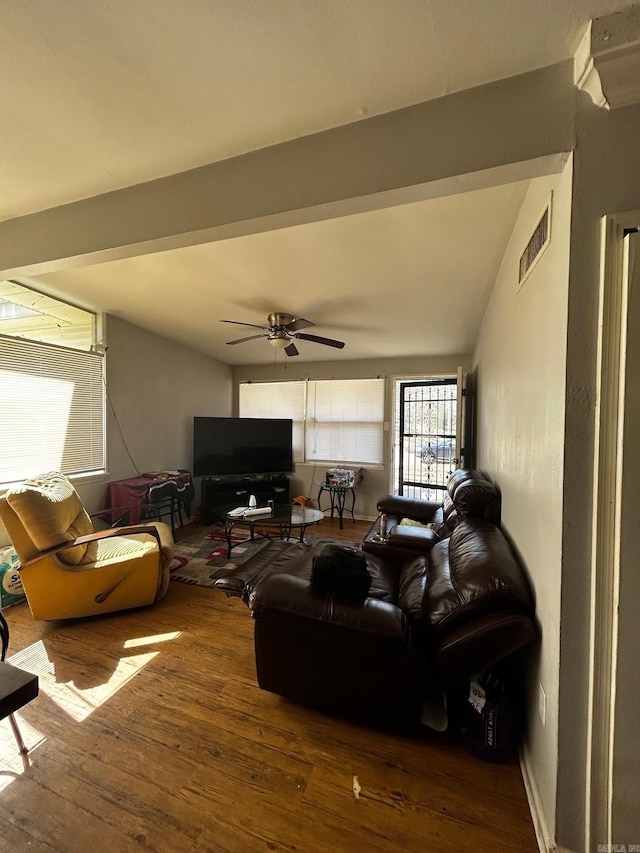 living room with wood-type flooring, visible vents, and ceiling fan