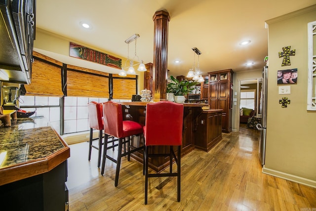 kitchen with crown molding, glass insert cabinets, and wood finished floors