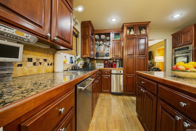 kitchen featuring tile countertops, decorative backsplash, stainless steel appliances, and a sink