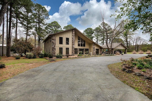 view of front facade featuring stone siding and aphalt driveway