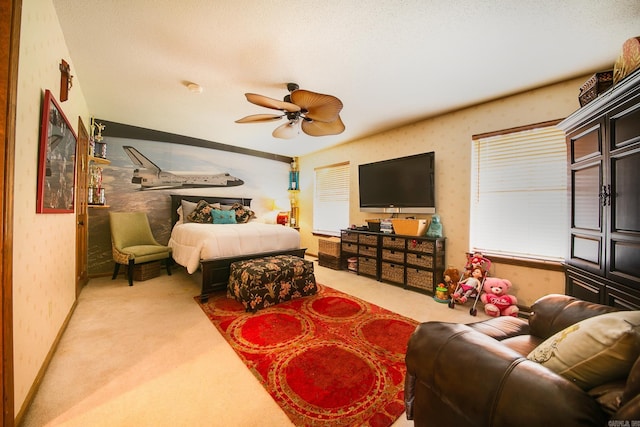 bedroom with a ceiling fan, carpet, a textured ceiling, and wallpapered walls