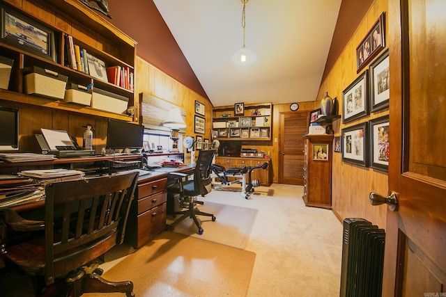 carpeted home office with radiator, vaulted ceiling, and wood walls