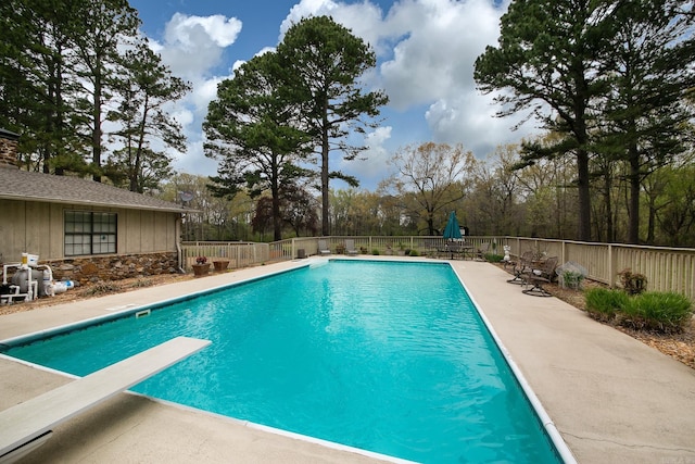 view of pool with fence, a diving board, a fenced in pool, and a patio