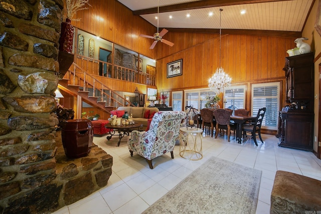 living area with stairway, wooden walls, high vaulted ceiling, beamed ceiling, and tile patterned floors