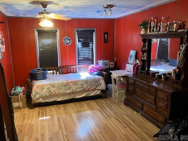 bedroom with a textured ceiling and wood finished floors