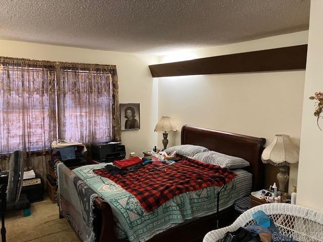 carpeted bedroom featuring a textured ceiling