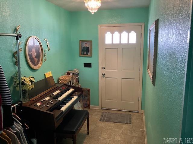 entrance foyer featuring an inviting chandelier and baseboards