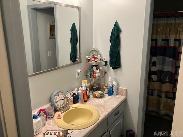 bathroom featuring curtained shower and vanity