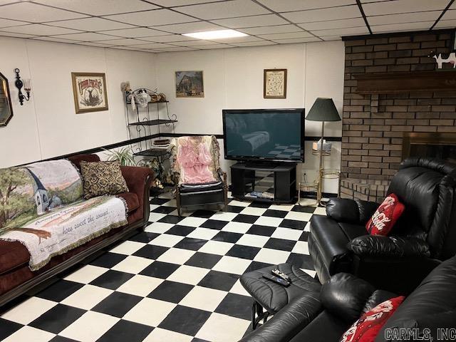 living area with a paneled ceiling and tile patterned floors