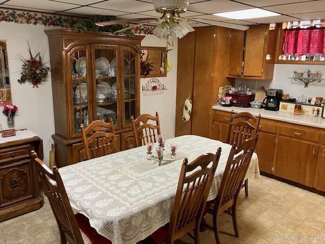 dining room featuring ceiling fan and a drop ceiling