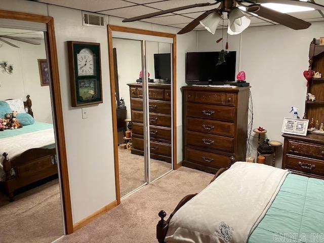 bedroom with carpet floors, ceiling fan, visible vents, and baseboards