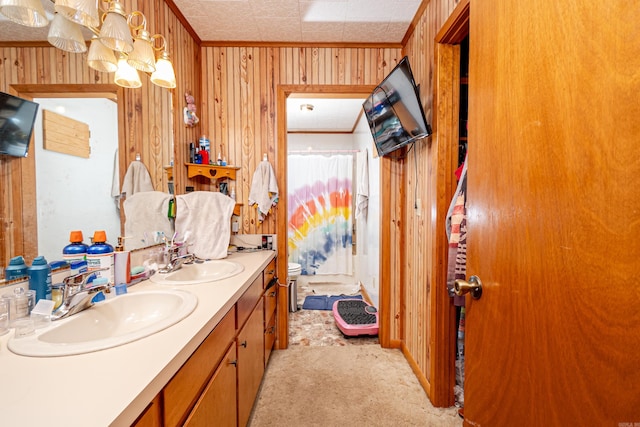 full bath with a sink, wooden walls, and double vanity