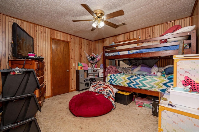 bedroom featuring carpet floors, wood walls, and ceiling fan