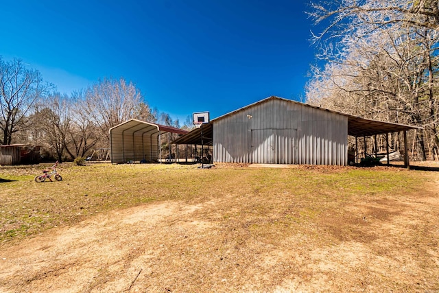 view of pole building with a carport and a yard