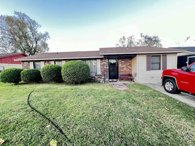 single story home with brick siding and a front lawn