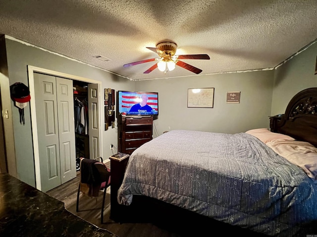 bedroom featuring a textured ceiling, a closet, a ceiling fan, and wood finished floors