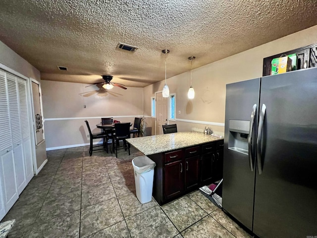 kitchen with visible vents, a ceiling fan, a peninsula, hanging light fixtures, and stainless steel refrigerator with ice dispenser